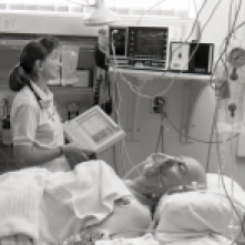 Critical Care nurse, Lily Foubert, checks a patient's vital signs using the Electronic Patient Information Chart, 1990.