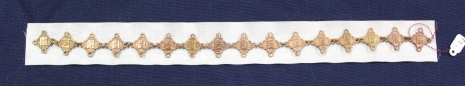 St. John's Ambulance brass labels linked together, each bearing the number 166455 and a year ranging from 1918-1934. Fourteen of the labels have "H.N." [Home Nursing] on them, 1 has an "S"[Sanitation], and the other has "H.H." [Home Hygiene]
