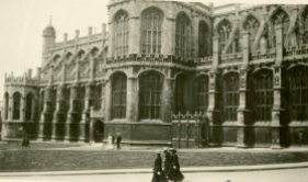 [Unidentified building with three nursing sisters walking by, England]